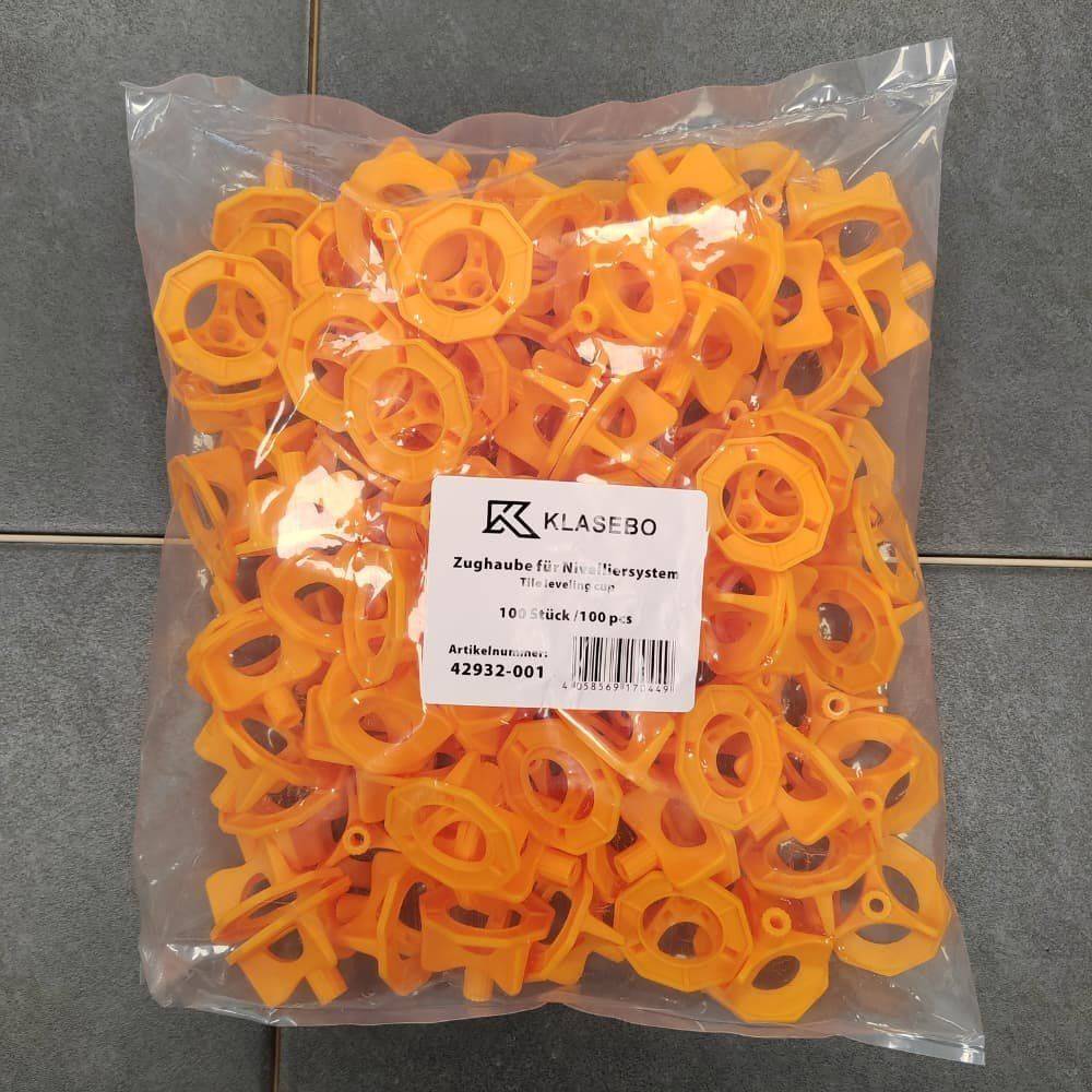 Ein Plastikbeutel gefüllt mit orangefarbenen Kunststoffkomponenten, mit dem Etikett „Klasebo Zughaube für Nivelliersystem, 100 Stück, Artikelnummer 42932-001