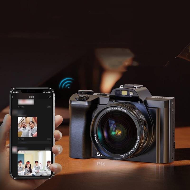 Eine Person hält ein Smartphone, das Fotos anzeigt, neben einer Digitalkamera auf einem Holztisch. Die Umgebung ist schwach beleuchtet und deutet auf die Nutzung im Innenbereich hin.