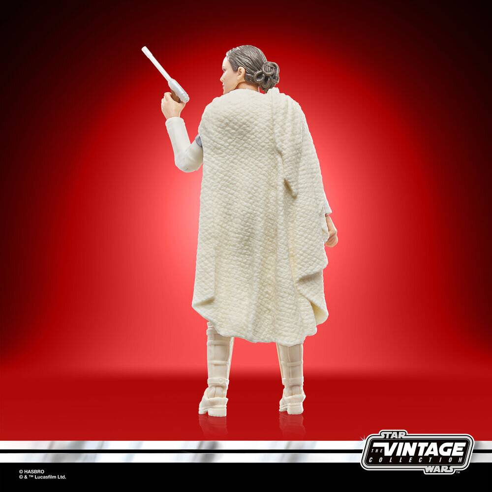 Eine Spielzeugfigur einer Figur, die einen langen weißen Umhang trägt und einen Stab hält, mit dem Rücken zum Betrachter gegen einen roten Hintergrund posiert.