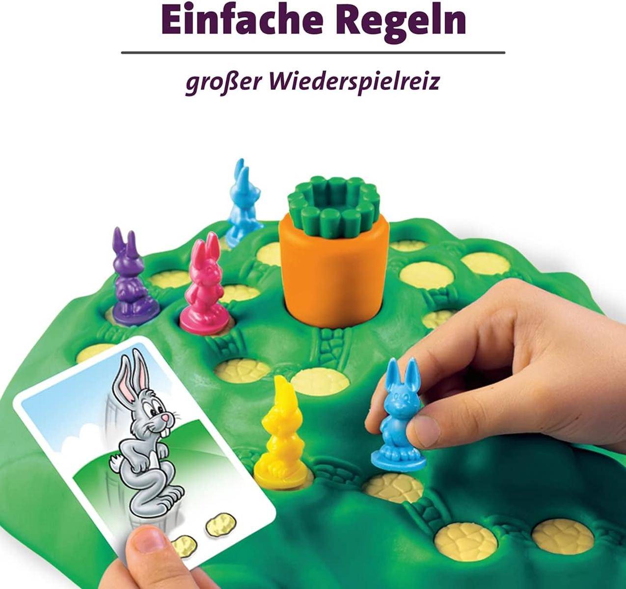 Eine Hand bewegt eine blaue Kaninchenfigur auf einem grünen Brettspiel mit farbenfrohen Kaninchen und einer gelben Karte mit einer grauen Kaninchenillustration.