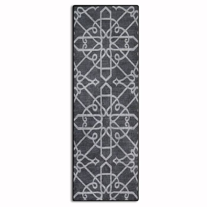 Ein grauer Teppich mit einem symmetrischen, aufwendigen weißen geometrischen Muster.