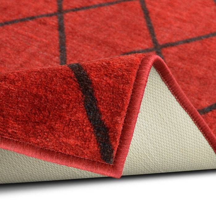 Rot karierter Teppich mit strukturierter Oberfläche, der ein schwarzes Gittermuster zeigt. Die Ecke ist umgeschlagen und zeigt die weiße rutschfeste Rückseite.