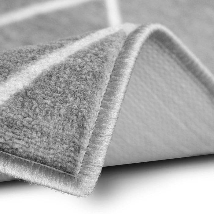 Nahaufnahme eines gefalteten Teppichs, der seine weiche Textur und die detaillierte Naht an den Kanten zeigt.