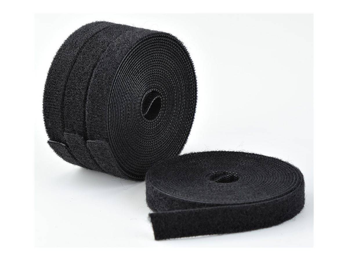 Zwei Rollen schwarzes Klettband, eine aufrecht und eine auf weißem Hintergrund abgerollt.
