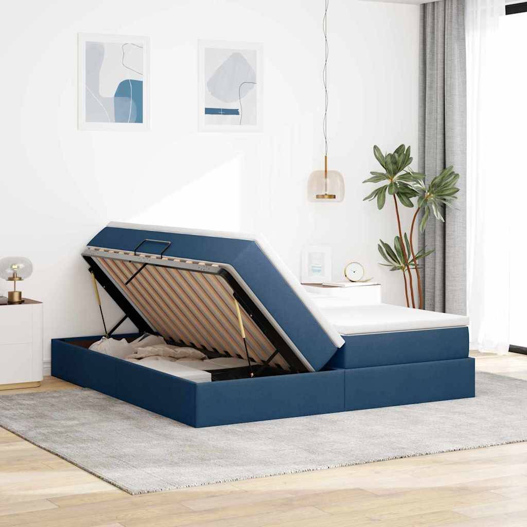 Ein modernes Schlafzimmer mit einem blau gepolsterten Bett mit Hubstauraum, einem grauen Teppich, Pflanzen und abstrakten Kunstwerken an weißen Wänden.