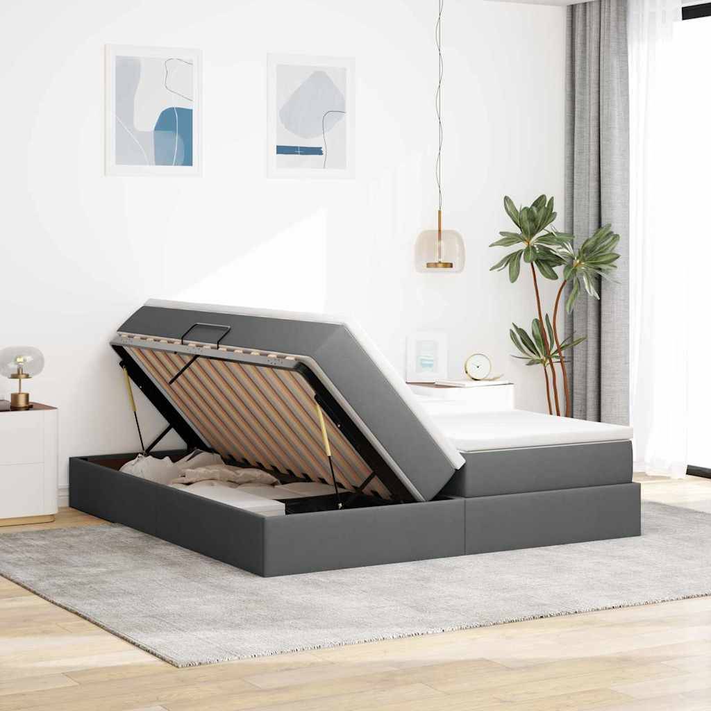 Ein modernes Schlafzimmer mit einem grauen Boxspringbett mit Stauraum auf einem grauen Teppich, weißen Wänden, die mit abstrakter Kunst dekoriert sind, und einem Nachttisch mit einer Lampe.