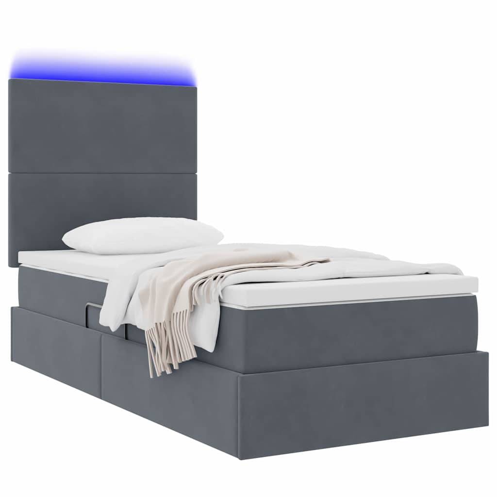Ein modernes graues Bett mit hohem Kopfteil, ausgestattet mit integrierten Schubladen zur Aufbewahrung und einer leuchtenden blauen Kopfteilleuchte, belegt mit Kissen und einer beigen Wurfdecke.