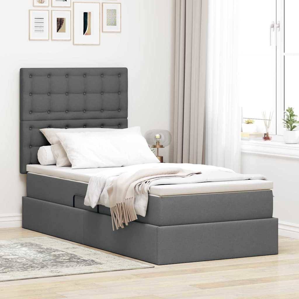 Ein modernes Schlafzimmer verfügt über ein grau gepolstertes Bett mit integriertem Stauraum, weiße Bettwäsche, einen Nachttisch und Wandkunst über dem Kopfteil.