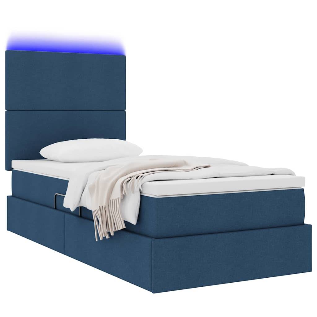 Ein blau gepolstertes Bett mit einem Kopfteil, Kissen und weißer Decke. Das Kopfteil verfügt über eine lila LED-Leuchte.
