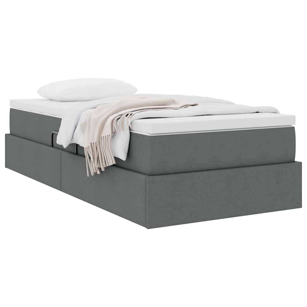 Ein grau gepolstertes Plattformbett mit minimalistischem Design, ausgestattet mit einer weißen Matratze, einem Kissen und einer beige Wurfdecke, die ordentlich drapiert ist.