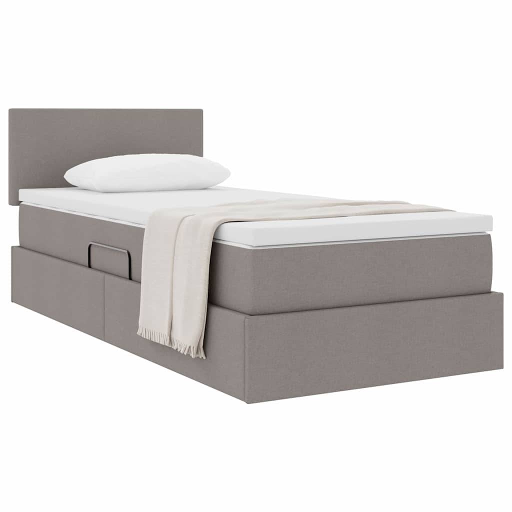 Ein grau gepolstertes Bett mit Kopfteil, weißem Kissen und beigefarbener Wurfdecke. Das Bett verfügt über zwei Schubladen zur Aufbewahrung auf einer Seite.