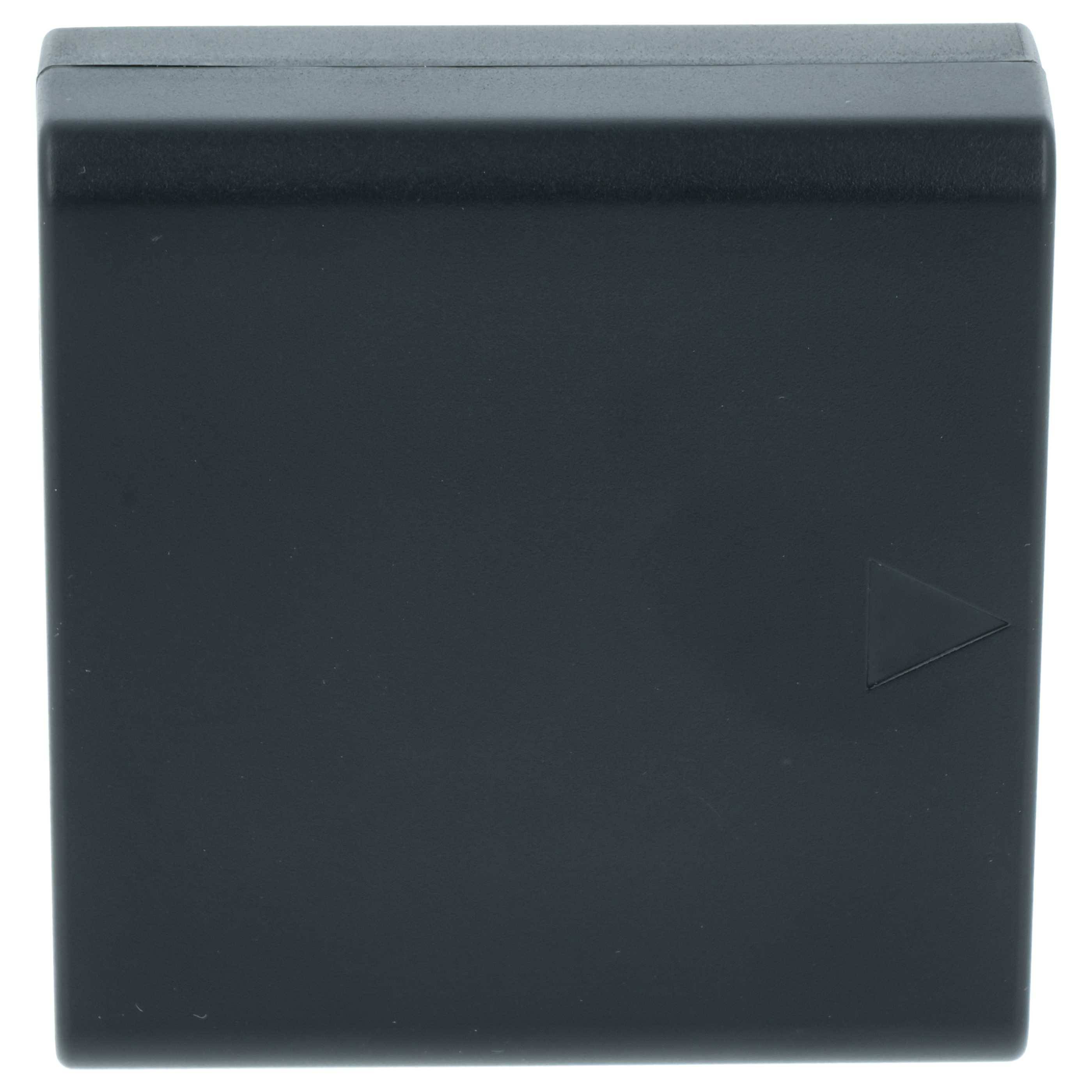 Ein kleines schwarzes quadratisches Kunststoffobjekt mit einem einfachen Dreieck-Symbol auf einer Seite.