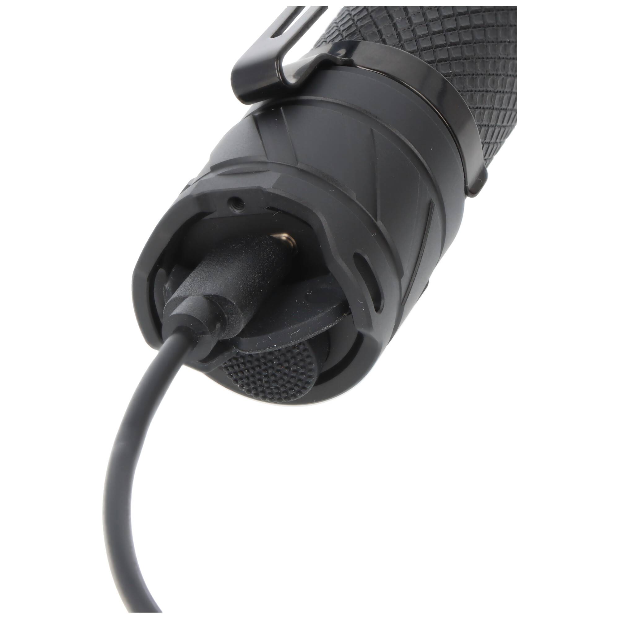 Eine Nahaufnahme einer Taschenlampe mit strukturiertem Griff, in deren Unterseite ein Ladekabel eingesteckt ist, was darauf hinweist, dass sie wiederaufladbar ist.