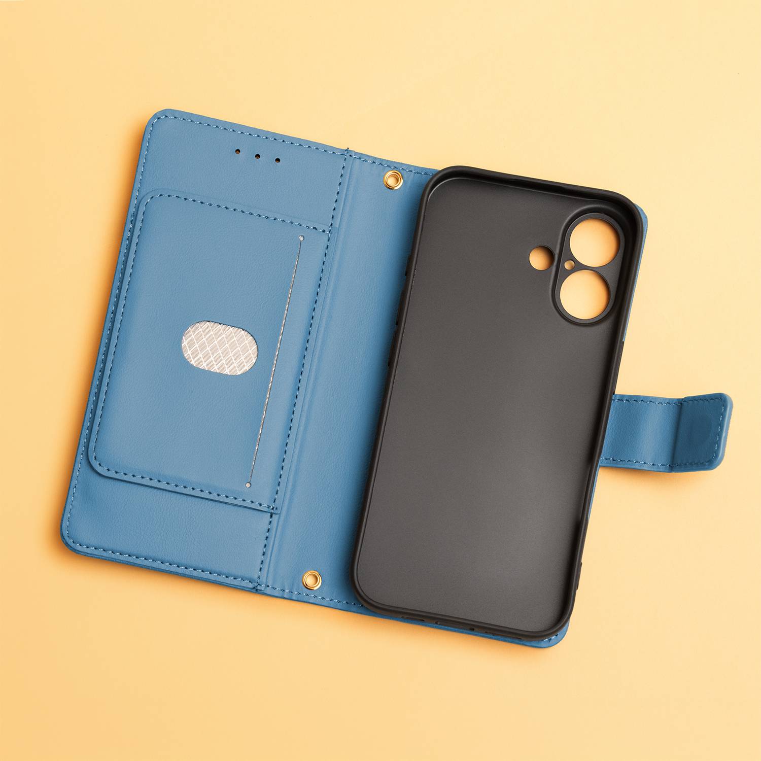 Eine blaue Telefon-Brieftaschenhülle liegt geschlossen auf hellorangefarbenem Hintergrund und zeigt die strukturierte Oberfläche und den magnetischen Verschluss.