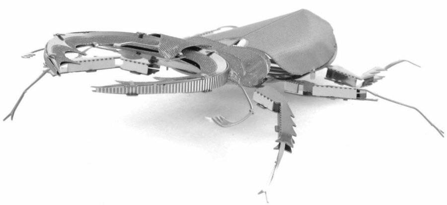 Ein silberfarbener Roboterkäfer mit gelenkigen Beinen und Fühlern, der einem Insekt ähnelt, gezeigt vor einem einfachen weißen Hintergrund.