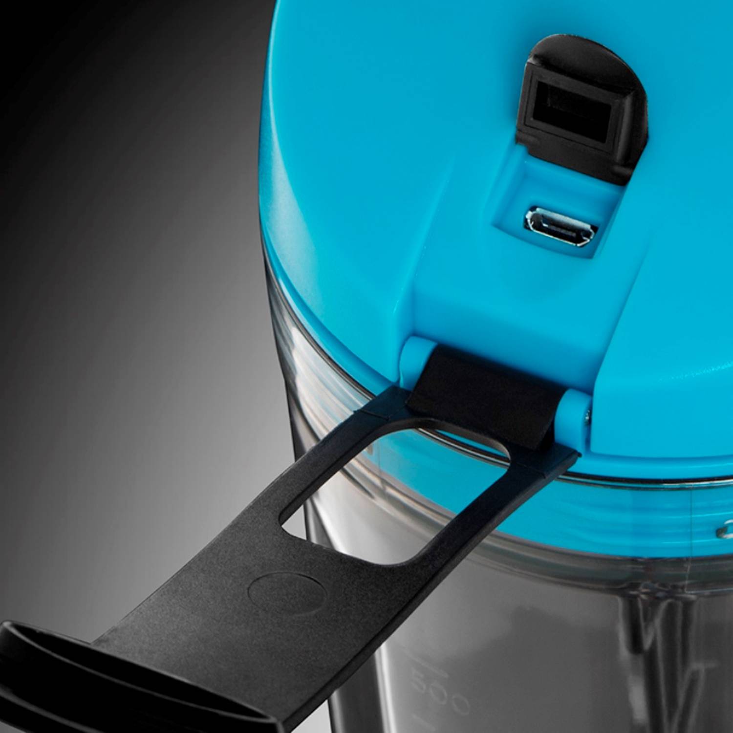 Eine Nahaufnahme eines Mixerdeckels mit blauem Oberteil, mit einer schwarzen Auslaufabdeckung und USB-Ladeanschluss.
