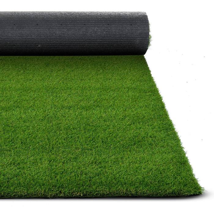 Eine Rolle grüner Kunstrasen, teilweise ausgerollt, die Textur und Rückseite zeigend, vor weißem Hintergrund.