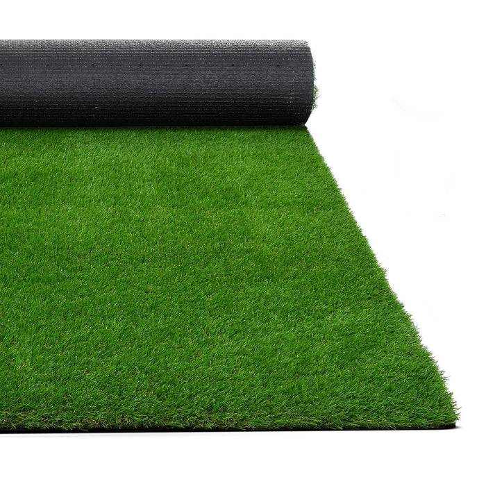 Eine teilweise ausgerollte Kunstrasen-Rolle, die helles grünes Kunststoffgras und eine schwarze Rückseite zeigt, verwendet für Landschaftsgestaltung oder Sportplatzoberflächen.