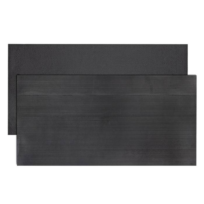 Zwei schwarze strukturierte Gummimatten, eine kleinere vorne und eine größere dahinter, die ihre unterschiedlichen Größen zeigen.