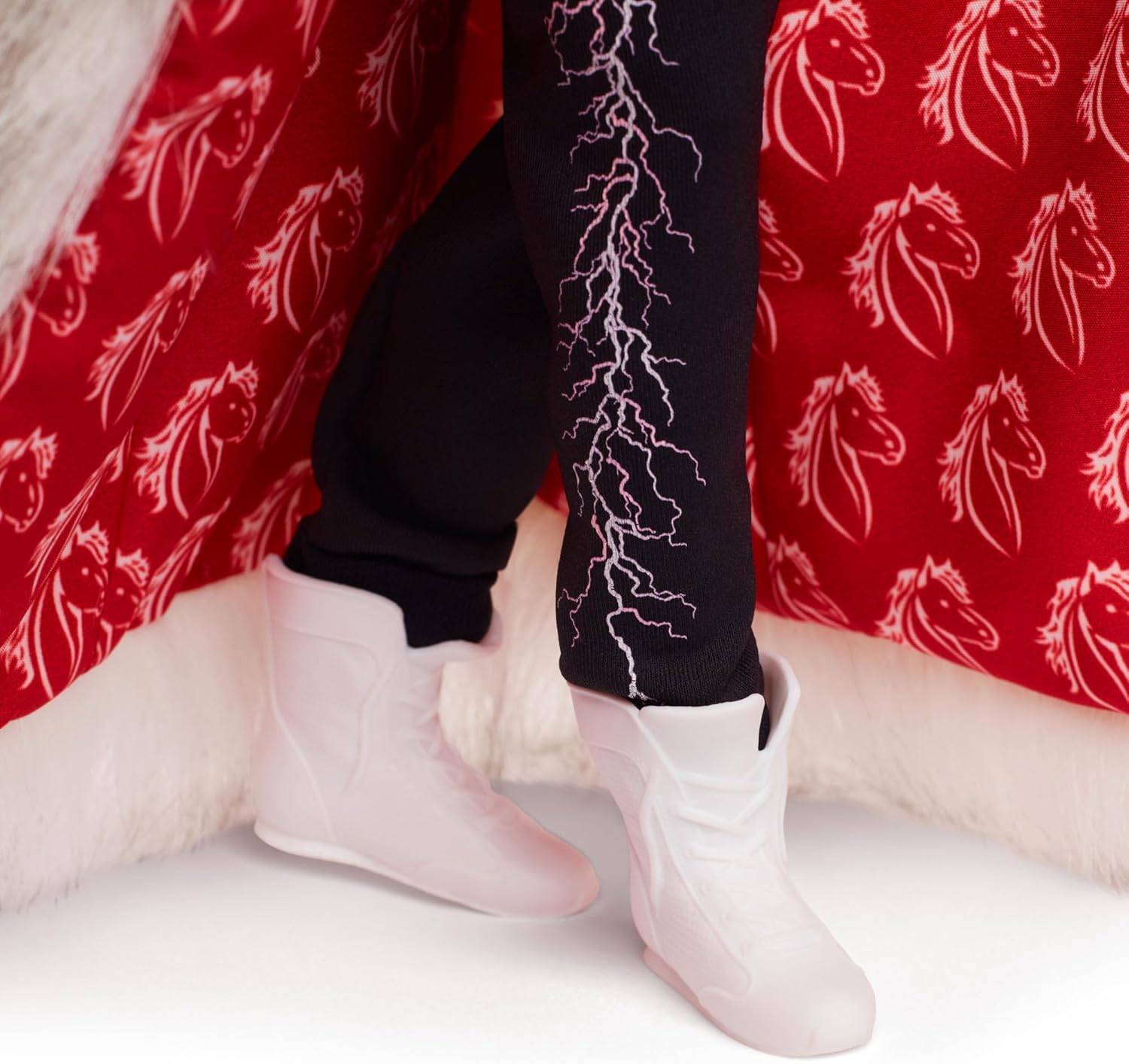 Weiße Stiefel und schwarze Hosen mit rosa Blitzmuster, vor einem roten Hintergrund mit weißen Pferdegrafikern.