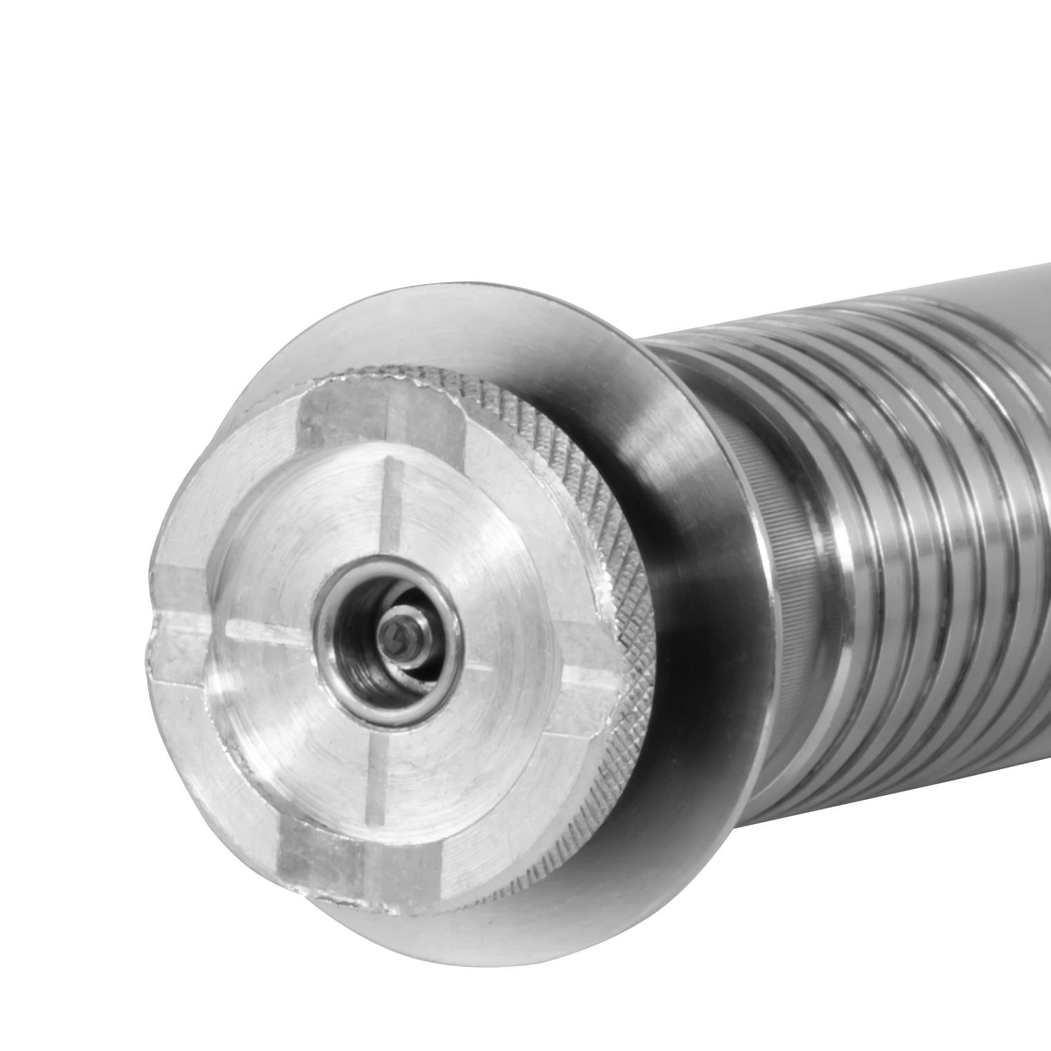 Eine Nahaufnahme einer metallischen mechanischen Komponente mit einem zylindrischen, gerippten Körper, die ein zentrales Loch aufweist, das wahrscheinlich für hydraulische oder pneumatische Zwecke bestimmt ist.