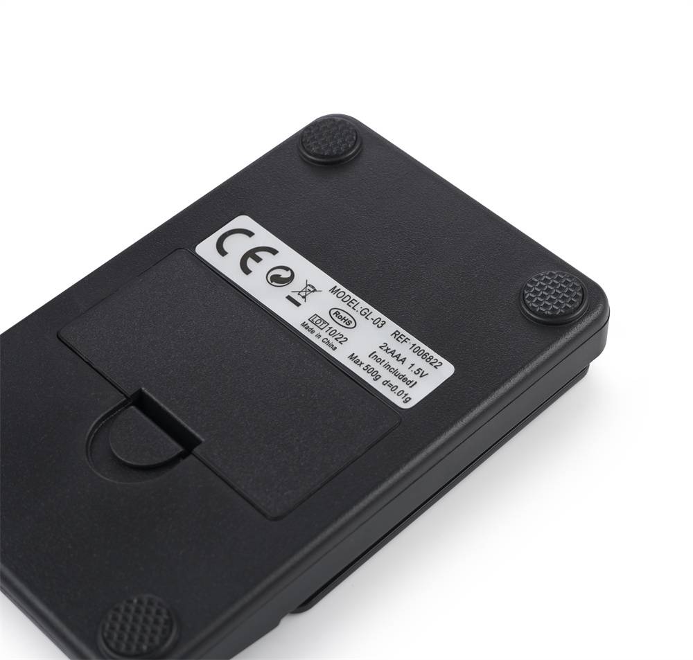 Ein rechteckiges schwarzes elektronisches Gerät mit Gummifüßen und einem Etikett mit Modellangaben und Sicherheitssymbolen.