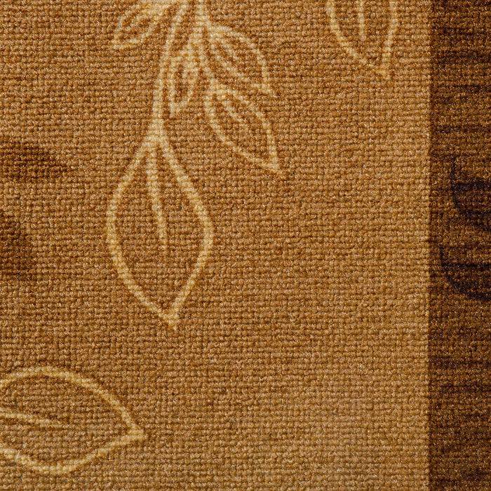 Ein braunes strukturiertes Textilgewebe mit einem besticktem Blattmuster in hellen Beigetönen.