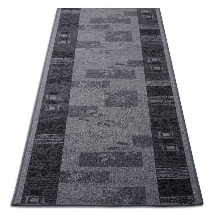 Grauer Teppich mit geometrischem und floralem Design, mit rechteckigen Mustern und subtilen Blattmotiven in verschiedenen Grautönen.