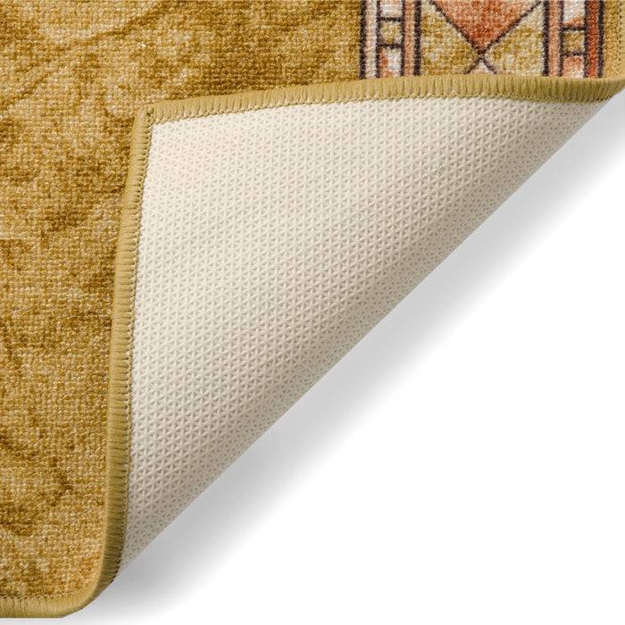 Eine Nahaufnahme einer ecke eines beigen, gemusterten teppichs mit einer nach oben gerollten kante, die eine rutschfeste unterseite zeigt.