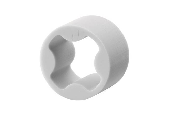 Weißes, kreisförmiges Kunststoffobjekt mit glatter Außenfläche und einem welligen, sternförmigen Inneren.