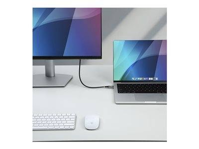 Ein Laptop ist mit einem Monitor auf einem weißen Schreibtisch verbunden. Eine Tastatur und eine Maus befinden sich vor dem Monitor.