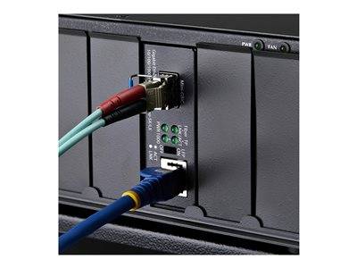 Eine Nahaufnahme eines Netzwerkgeräts mit angeschlossenen Ethernet- und Glasfaserkabeln, neben Anzeigeleuchten, die den Netzwerkstatus anzeigen.