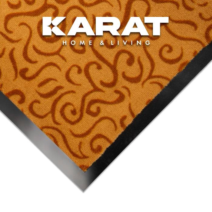 Gemusterter Textilstoff mit wirbelnden braunen Designs auf orangefarbenem Hintergrund, mit dem Text „KARAT HOME & LIVING