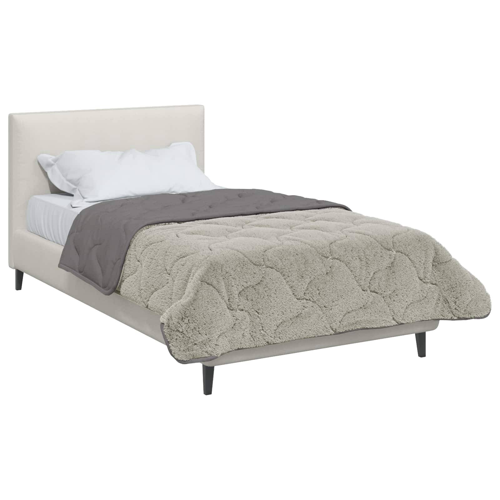 Ein beigefarbenes gepolstertes Bett mit weißen Kissen und einer grauen Decke, mit einer strukturierten hellbeigen Bettdecke.