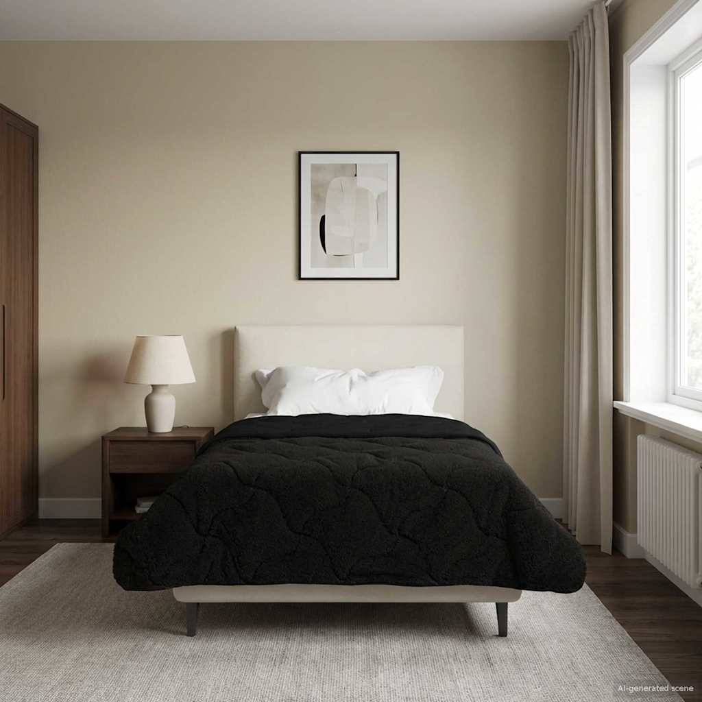 Ein modernes Schlafzimmer mit einem ordentlich gemachten Bett in schwarzer Bettwäsche. Eine Lampe auf einem hölzernen Nachttisch und ein gerahmtes abstraktes Kunstwerk hängt über dem Bett.
