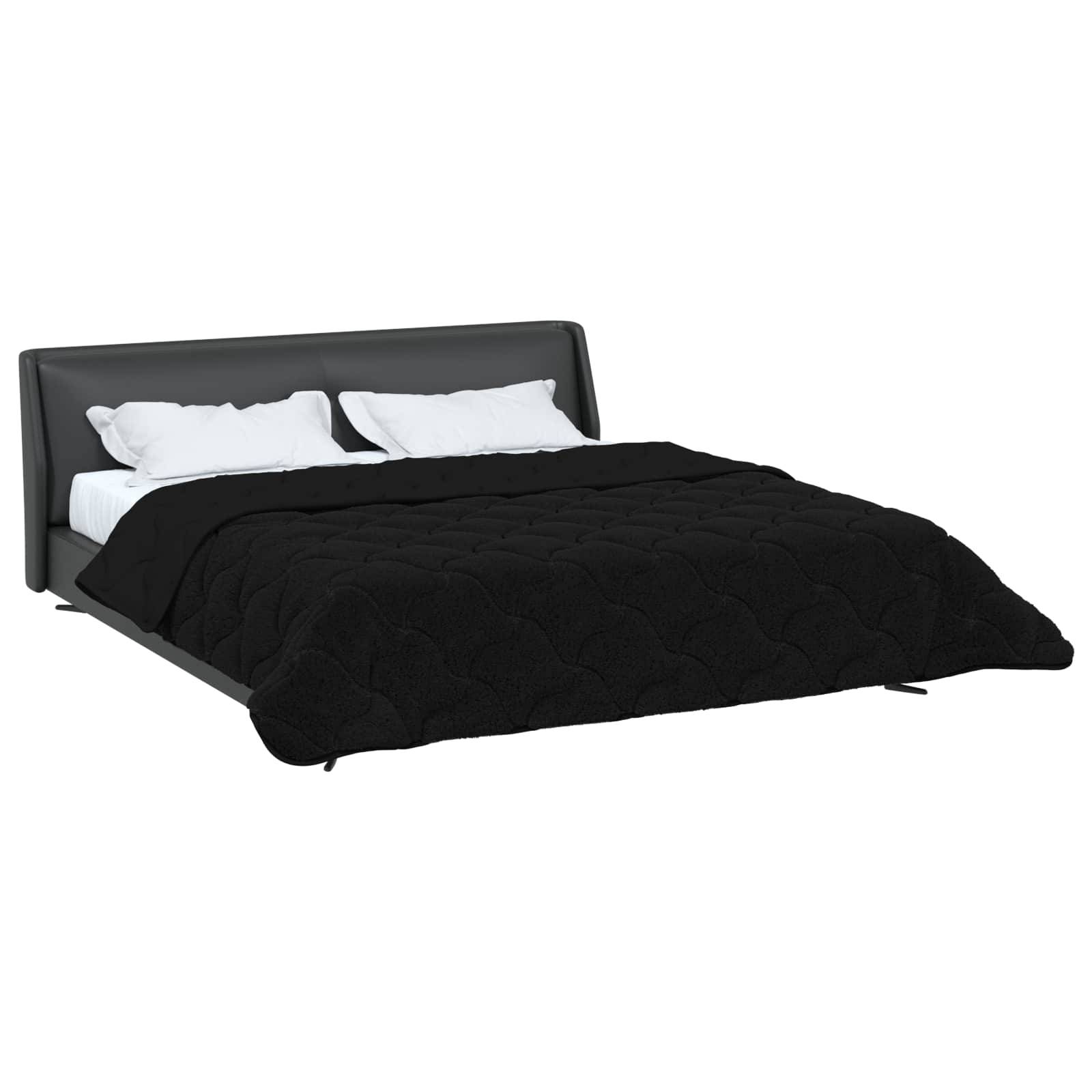 Ein Bett mit einer schwarzen gesteppten Decke und weißen Kissen auf einem dunklen Rahmen. Das Bett ist ordentlich gemacht und zeigt ein modernes und minimalistisches Design.