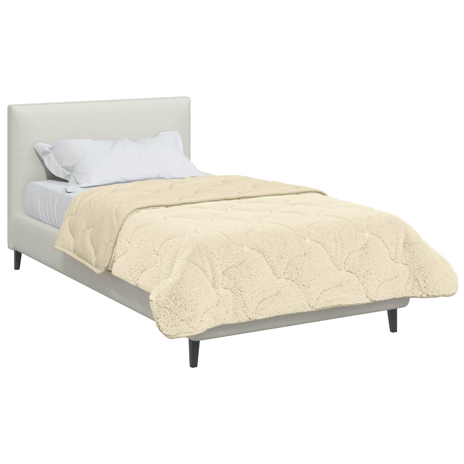 Ein ordentlich gemachtes Bett mit einer weichen, flauschigen beige Decke und zwei weißen Kissen gegen ein hellgefärbtes Kopfende.