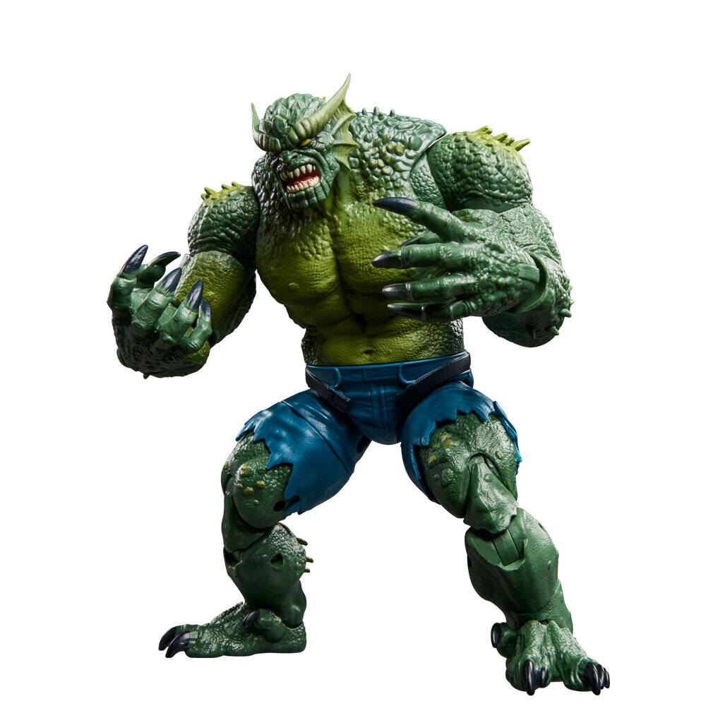 Grüne reptilienartige Monsterfigur mit Hörnern und Krallen, aggressiv posiert in blauen Shorts vor weißem Hintergrund.