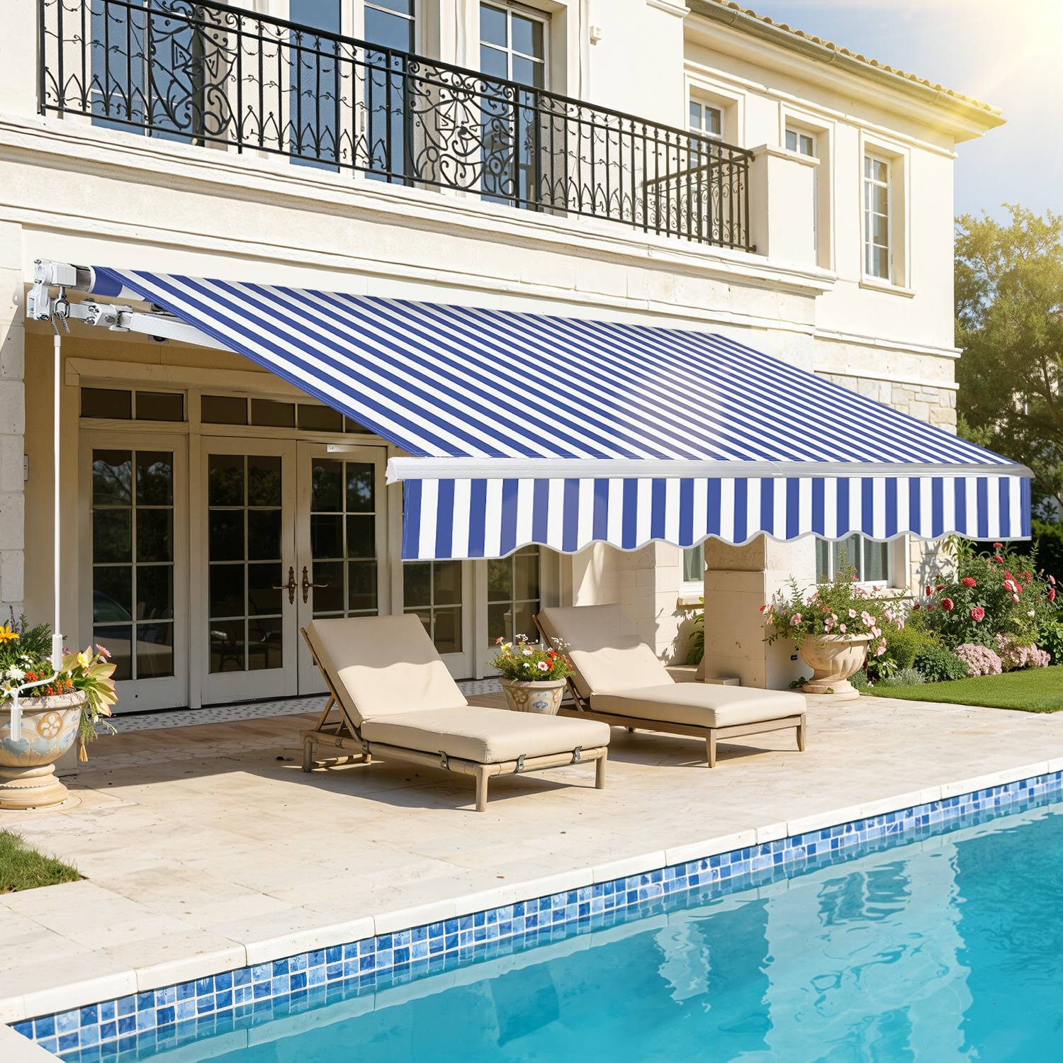Eine Terrasse mit zwei Liegestühlen und einer gestreiften blau-weißen Markise, die Schatten spendet, neben einem Pool, vor einem zweistöckigen Haus.