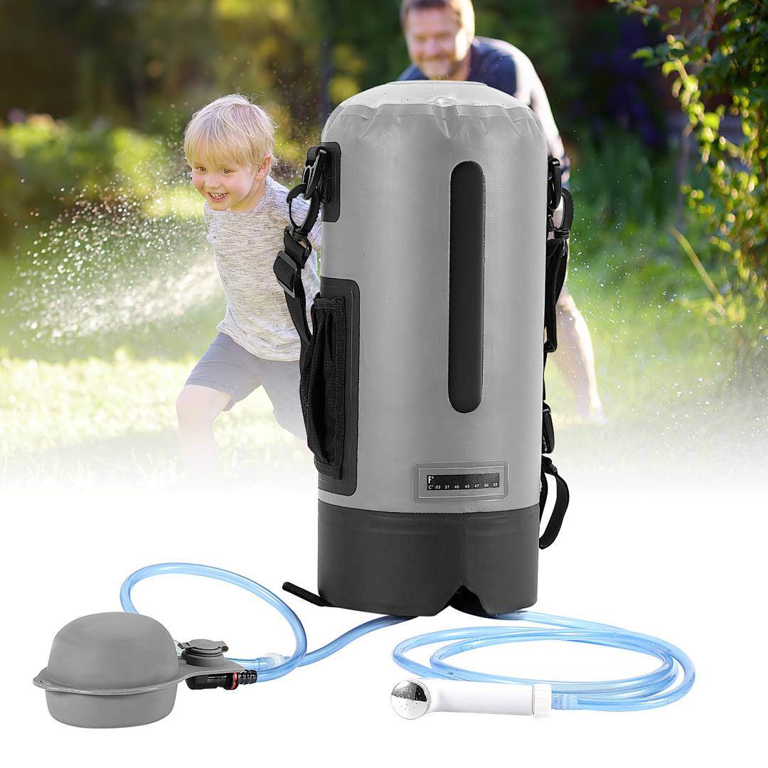 Ein Kind und ein Erwachsener spielen an einem sonnigen Tag in einem Garten unter einer Wasserstrahlung, mit einem tragbaren Duschasystem im Vordergrund.
