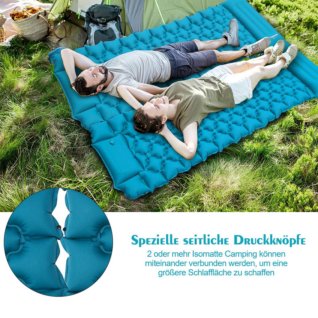 Ein Paar, das sich auf einer blauen aufblasbaren Campingmatte vor einem Zelt entspannt, demonstriert deren Verwendung und hebt die seitlichen Schnappverschlüsse hervor.