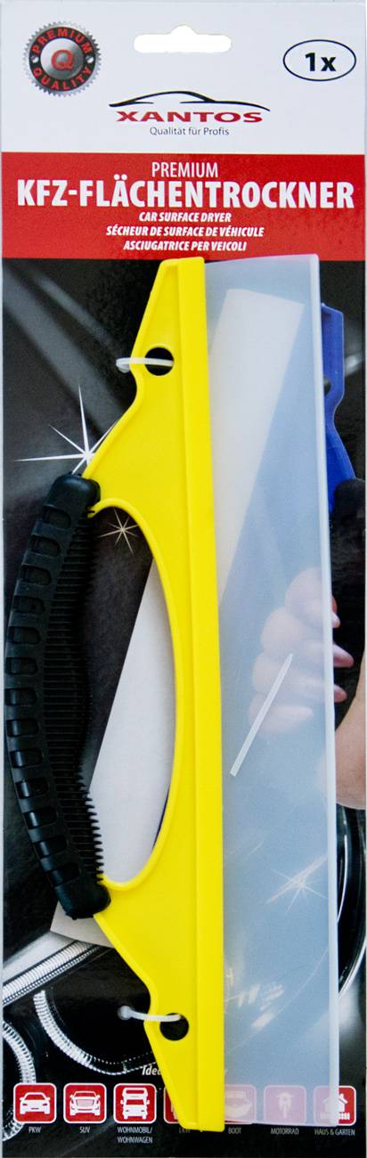 Eine Hand hält ein gelb-schwarz gefärbtes Werkzeug mit einer breiten blauen Klinge, wahrscheinlich ein Abzieher, gegen eine reflektierende schwarze Oberfläche positioniert.