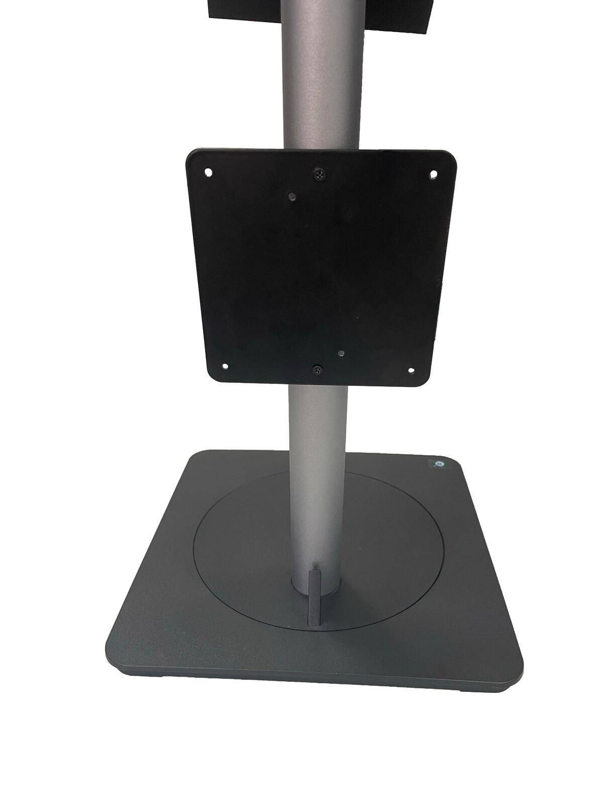 Eine schwarze quadratische Metallplatte auf einem vertikalen Pfosten, der auf einer flachen Basis positioniert ist.