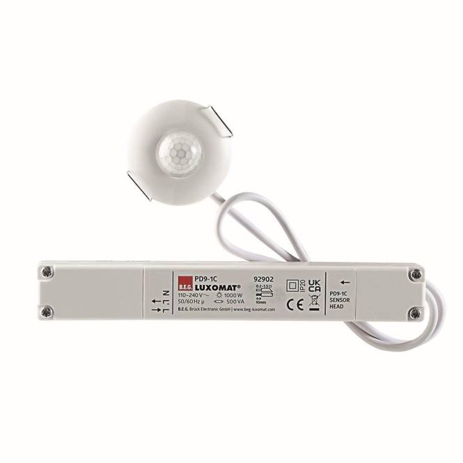 Sensor mit einem weißen kreisförmigen Detektor, der über ein Kabel an eine rechteckige Kontrollbox angeschlossen ist. Die Kontrollbox zeigt die Marke und technische Spezifikationen an.