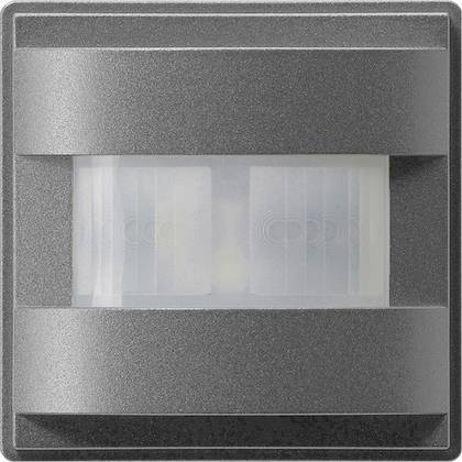 Ein quadratischer grauer Bewegungsmelder mit einem zentralen durchscheinenden Feld zur Bewegungserkennung.