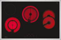 Elektrisches Kochfeld mit leuchtend roten Kochstellen in rund- und ovalformen auf schwarzer Oberfläche.