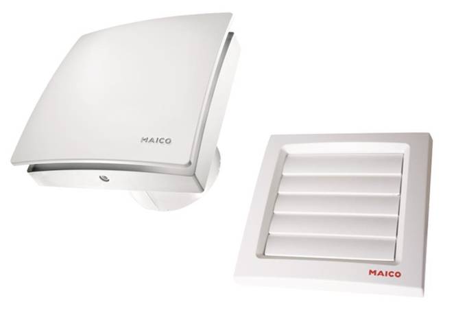 Ein weißer, wandmontierter Lüftungsventilator auf der linken Seite und eine Lüftungsabdeckung mit horizontalen Lamellen auf der rechten Seite. Beide sind mit 'MAICO' gekennzeichnet.