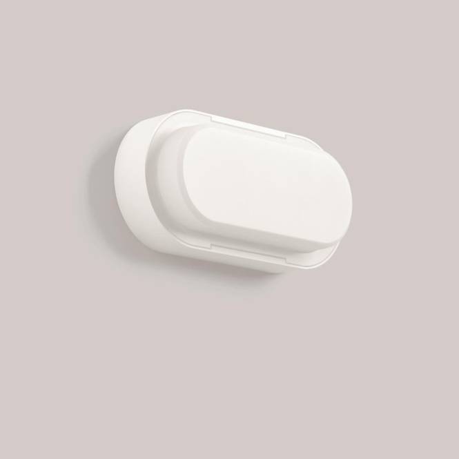 Eine weiße, rechteckige Türklingel mit abgerundeten Kanten, die an einer hellgrauen Wand montiert ist.