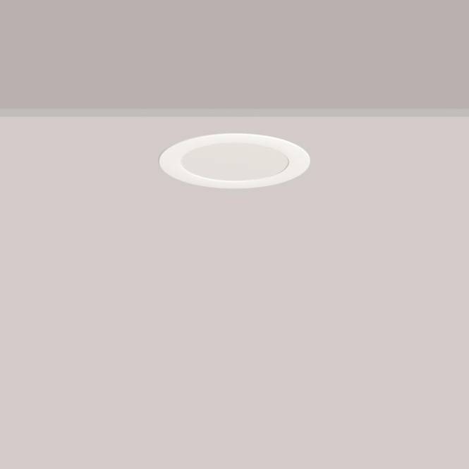 Eine runde Deckenleuchte in einem minimalistischen Raum mit hellgrauen Wänden.