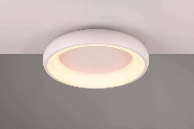 Ein runder, moderner Deckenleuchte strahlt ein warmes Licht aus und verbessert die Umgebungsbeleuchtung in einem minimalistischen Innenraum.